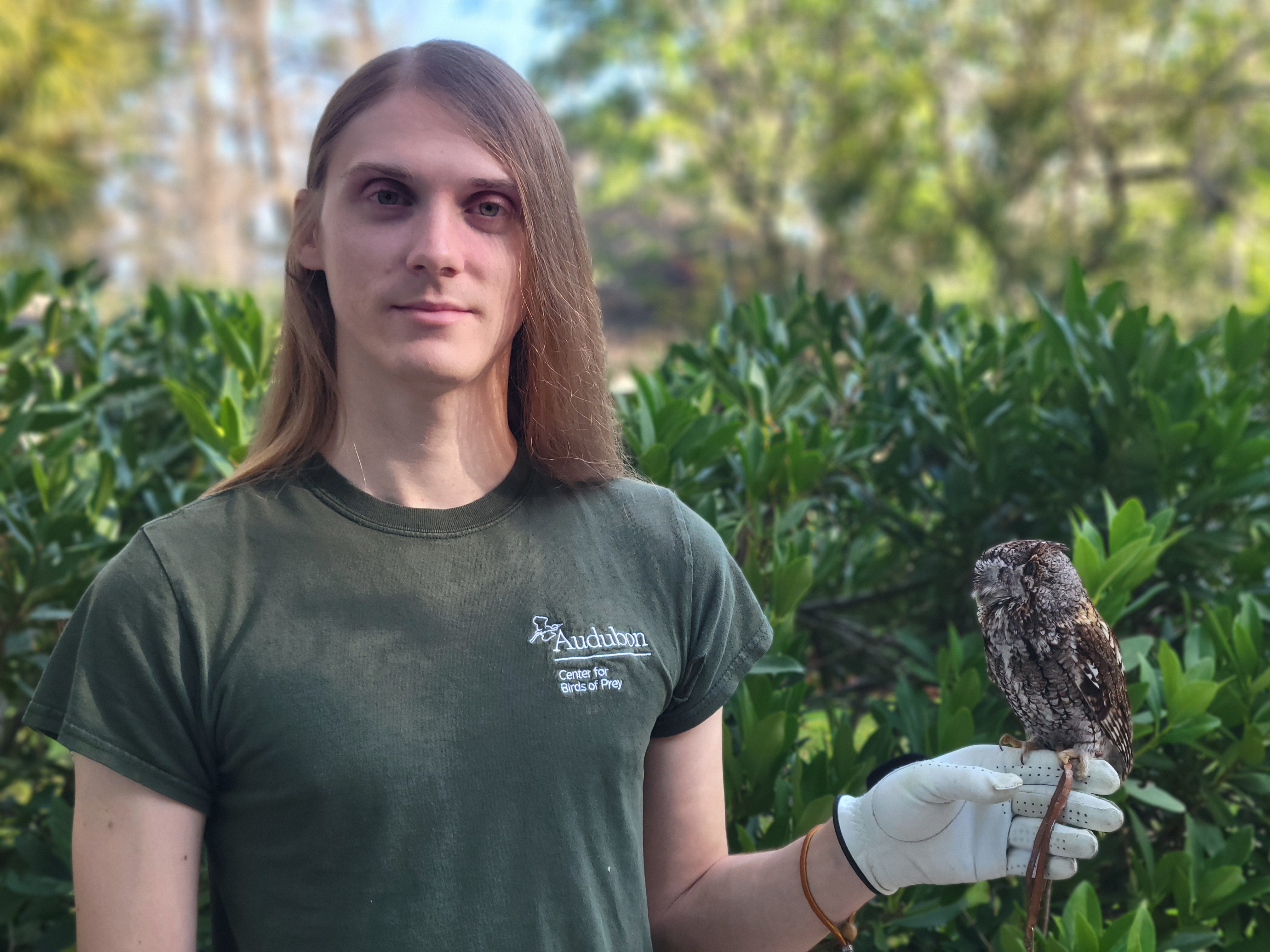A portrait of Cameron holding an Eastern Screech-Owl on his gloved hand.
